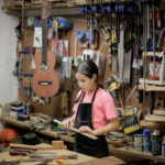 Ava Delgado, apprentice luthier, prepares a measurement.