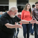 Louis Frazor, master, helps lead dancers through a square dance set, at the Breaking Up Winter event in Lebanon, in March 2018.