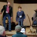 Thomas Maupin, master, and Jack Fennell, apprentice, demonstrate their distinctive buck dancing styles, on stage at the Breaking Up Winter event, in March 2018.