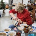 Sue Williams, master, trimming a rib of a white oak basket in progress.