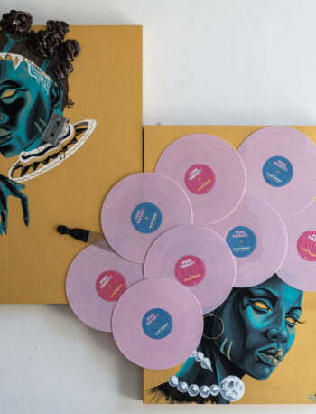 Two yellow square canvases on a white wall feature stylized portraits of Black women in blue tones. Nine pink vinyl records are arranged in a cluster across both canvases, partially covering the lower portrait.