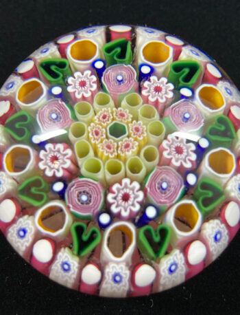 Damon MacNaught, Pink and Green Paperweight, glass, 2.5” diameter, 2024. Floral Concentric paperweight, vibrant colors symmetrically arranged. Green Hearts arranged in 5th row exploring mortality in the cycle of life.